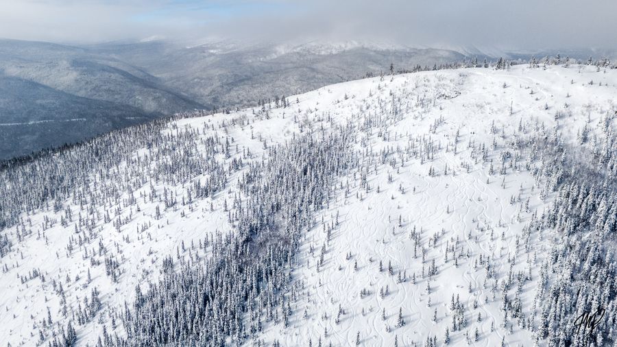 Aerial view of a snowy ridge with ski tracks