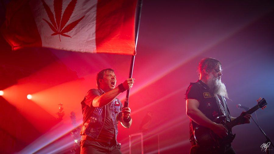 Singer waving a flag on stage in red light
