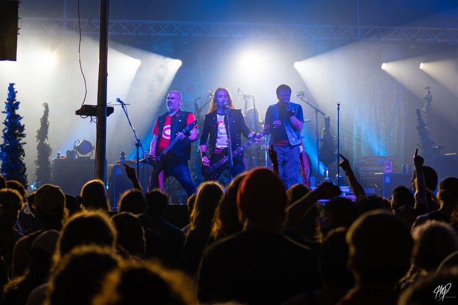 Band on stage with a crowd raising their hands